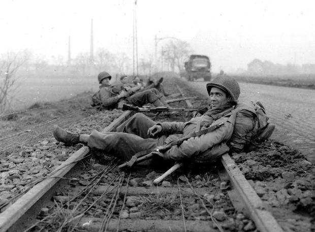 Battle-of-the-Bulge-Tour-During-the-Battle-of-the-Bulge-GIs-of-the-Timberwolf-Division-resting-on-the-rails-after-combat-in-Düren-21-December-1944-Virtuoso-Battle-Tours